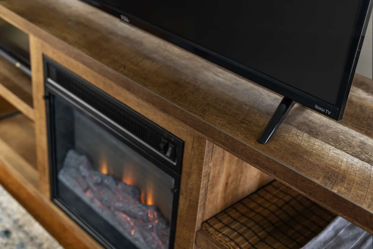 The living room is the centerpiece here, with a prominent Roku TV above a wooden console and an electric fireplace beneath. Cozy seating creates a welcoming atmosphere ideal for movie nights and unwinding after a busy day.
